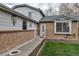 Close up shot of the brick home with large front window, a walkway, and mature landscaping at 45 Pierce St, Lakewood, CO 80226