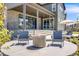 Inviting covered back patio with a stone accent wall, fire pit, and seating for entertaining at 6677 Crossbridge Cir, Castle Rock, CO 80108