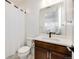Bathroom featuring white countertops, dark wooden cabinetry and a shower-tub with neutral-tone shower curtain at 6677 Crossbridge Cir, Castle Rock, CO 80108