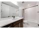 Bathroom featuring a large mirror, vanity with dark cabinets, and a shower-tub combo at 6677 Crossbridge Cir, Castle Rock, CO 80108