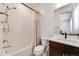 Well-lit bathroom with a shower-tub combo, white tile, and neutral finishes throughout at 6677 Crossbridge Cir, Castle Rock, CO 80108