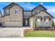 Beautiful two-story home featuring a stone facade, well-manicured lawn, and a spacious three car garage at 6677 Crossbridge Cir, Castle Rock, CO 80108