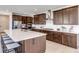 Stylish kitchen with stainless steel appliances, white countertops, a large island with seating, and dark wood cabinetry at 6677 Crossbridge Cir, Castle Rock, CO 80108