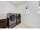 Laundry room with front loading washer and dryer, tile floor, and large windows at 6677 Crossbridge Cir, Castle Rock, CO 80108