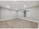 A finished basement showcases an egress window, recessed lighting, and stylish, wide-plank flooring at 334 S Revere St, Aurora, CO 80012