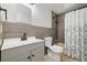 Bathroom featuring updated sink, toilet, and shower with tiled walls at 334 S Revere St, Aurora, CO 80012