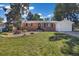Brick house featuring a lush front lawn, mature trees, and a driveway leading to the garage at 334 S Revere St, Aurora, CO 80012