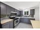Kitchen featuring stainless steel appliances, gray cabinets, and a tiled backsplash at 334 S Revere St, Aurora, CO 80012