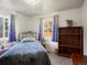 Bright bedroom featuring a blue bedspread, two windows, and ample natural light at 6801 W 52Nd Ave, Arvada, CO 80002