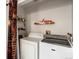 Bright laundry room features modern washer and dryer, plus convenient storage shelves at 6801 W 52Nd Ave, Arvada, CO 80002