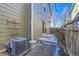 Exterior view of a home with a sliding glass door opening onto a patio and a fenced yard with gravel and plants at 2032 Spruce St, Denver, CO 80238