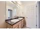 Bathroom featuring neutral tile, double sinks and bright vanity lighting at 2032 Spruce St, Denver, CO 80238