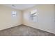 Bright bedroom featuring neutral carpet, walls and two windows at 2032 Spruce St, Denver, CO 80238