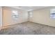 A simple bedroom with neutral walls and carpet and two windows at 2032 Spruce St, Denver, CO 80238