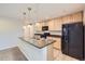 Bright kitchen with stainless steel appliances, light wood cabinets, and island with sink at 2032 Spruce St, Denver, CO 80238