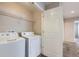 Convenient laundry room features a washer, dryer, wire shelving, and a door leading to another area of the home at 2032 Spruce St, Denver, CO 80238