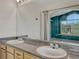 Bathroom vanity with double sinks, framed mirror, and natural wood cabinetry at 3630 Sawgrass Trl, Castle Rock, CO 80109