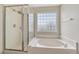 Bright bathroom features a soaking tub with tiled surround and a separate shower with glass door at 3630 Sawgrass Trl, Castle Rock, CO 80109