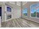Open living room with a fireplace, stylish gray flooring, and abundant natural light from large windows at 3630 Sawgrass Trl, Castle Rock, CO 80109