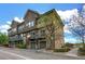 Three-story townhome exterior with private balconies, green garage doors, and stone accents at 18766 E Yale Cir # A, Aurora, CO 80013