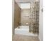 Bathtub with tan tiled wall and decorative shower curtain at 18766 E Yale Cir # A, Aurora, CO 80013