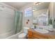 Full bathroom with shower-tub combo, white tile, and updated fixtures at 225 Longspur Dr, Brighton, CO 80601