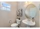 Neat powder bathroom with a pedestal sink, and decorative mirror at 225 Longspur Dr, Brighton, CO 80601