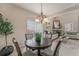 Cozy dining area featuring a wooden table, chandelier lighting, and access to the living room at 225 Longspur Dr, Brighton, CO 80601