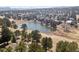 Picturesque aerial shot showcasing the property, lake, and surrounding lush landscape with mature trees at 31607 Broadmoor Dr, Evergreen, CO 80439