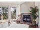 Cozy room area with fireplace and natural light from windows that feature views of the surrounding forest at 31607 Broadmoor Dr, Evergreen, CO 80439