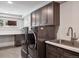 Convenient laundry area with modern washer, dryer, sink and ample cabinet space at 31607 Broadmoor Dr, Evergreen, CO 80439