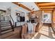 Cozy living room with a stone fireplace, wooden beams, and comfortable seating, creating a warm and inviting atmosphere at 31607 Broadmoor Dr, Evergreen, CO 80439