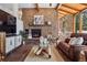 Inviting living room featuring a stone fireplace, wood ceilings, and plenty of natural light at 31607 Broadmoor Dr, Evergreen, CO 80439