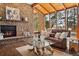 Inviting living room features a stone fireplace, wood ceiling, and large windows offering views of the surrounding landscape at 31607 Broadmoor Dr, Evergreen, CO 80439