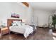Sun-drenched main bedroom features wood flooring, vaulted ceiling, and relaxing mountain landscape art at 31607 Broadmoor Dr, Evergreen, CO 80439