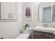 Stylish powder room with modern vanity, vessel sink, decorative art, and storage at 31607 Broadmoor Dr, Evergreen, CO 80439
