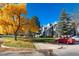 Autumn foliage surrounds a gray condo building with parking at 11109 Alcott St # D, Westminster, CO 80234