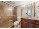 Bathroom features a glass-enclosed shower, wooden vanity, and updated fixtures at 601 W 11Th Ave # 109, Denver, CO 80204