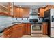 Cozy kitchen features wooden cabinets, stainless steel appliances, and unique backsplash at 601 W 11Th Ave # 109, Denver, CO 80204