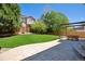 Private backyard features an open lawn, mature trees, and a cozy patio with seating at 4763 Laurelglen Ln, Highlands Ranch, CO 80130