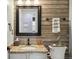 Half-bath boasts a wood accent wall, granite countertop, decorative mirror, and stylish fixtures at 4763 Laurelglen Ln, Highlands Ranch, CO 80130
