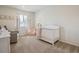 Bright Bedroom with a crib, chair, soft colors, and natural light at 4763 Laurelglen Ln, Highlands Ranch, CO 80130