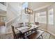 Bright dining room highlighting the wood floors, modern lighting, staircase, and natural light from windows at 4763 Laurelglen Ln, Highlands Ranch, CO 80130