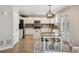 Bright kitchen features white cabinetry, island, stainless steel appliances, and a dining area with modern lighting at 4763 Laurelglen Ln, Highlands Ranch, CO 80130