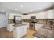 Well-lit kitchen boasts white cabinets, stainless steel appliances, granite countertops, and tile backsplash at 4763 Laurelglen Ln, Highlands Ranch, CO 80130