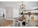 Bright kitchen features white cabinetry, island, stainless steel appliances, and a dining area with modern lighting at 4763 Laurelglen Ln, Highlands Ranch, CO 80130