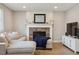 Cozy living room showing fireplace with mantle, wood floors, a sectional sofa, and a large television at 4763 Laurelglen Ln, Highlands Ranch, CO 80130