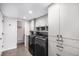 Well-organized laundry room featuring gray cabinets and modern washer and dryer units at 5115 E Davies Dr, Centennial, CO 80122