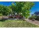 Spacious backyard featuring a wooden deck and large shade trees, perfect for outdoor relaxation and entertaining at 1572 W Long Ave, Littleton, CO 80120