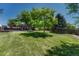 Lush backyard with mature trees offering shade and a view of the deck at 1572 W Long Ave, Littleton, CO 80120